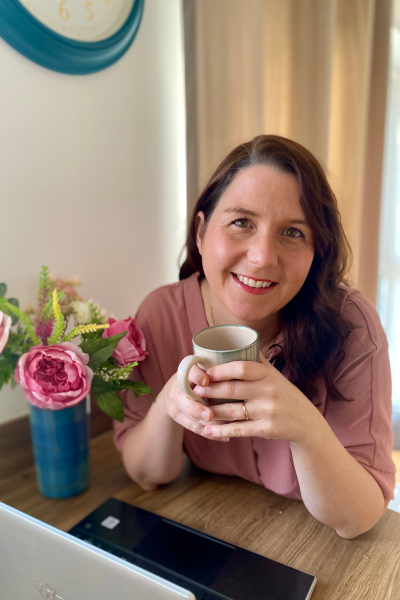 Jenny Brown holding mug at laptop